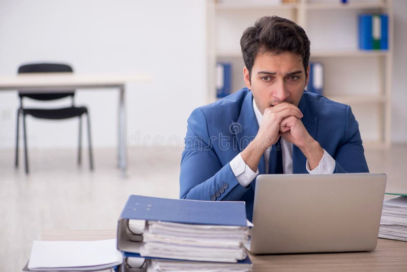 Young businessman employee and too much work at workplace. Young businessman employee and too much work at workplace