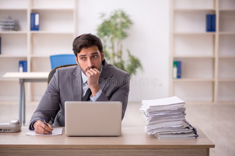Young businessman employee and too much work in the office. Young businessman employee and too much work in the office