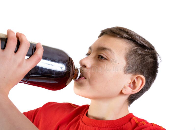 Young caucasian teenage boy drinking a cola drink from the bottle. Young caucasian teenage boy drinking a cola drink from the bottle