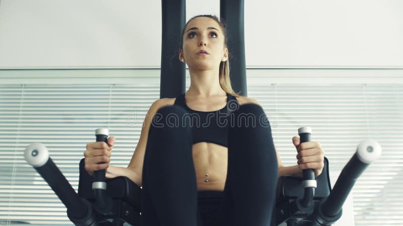 年轻的运动女性在健身房的探险站锻炼