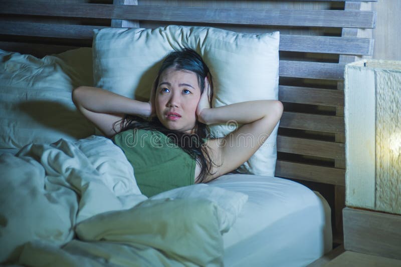 年轻美丽和被注重的亚裔中国妇女有说谎的失眠在床失眠的遭受的忧虑重音和偏头痛头 免版税库存图片 年轻美丽和被注重的亚裔中国妇女有说谎的失眠在床失眠的遭受的忧虑重音和偏头痛头 免版税库存图片