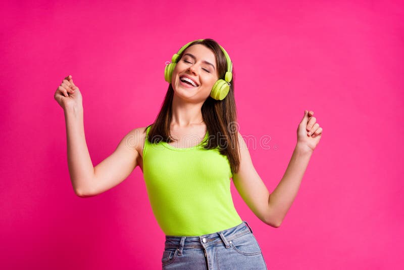 Photo of young attractive girl dance listen music earphones headphones enjoy happy smile isolated over pink color background. Photo of young attractive girl dance listen music earphones headphones enjoy happy smile isolated over pink color background.