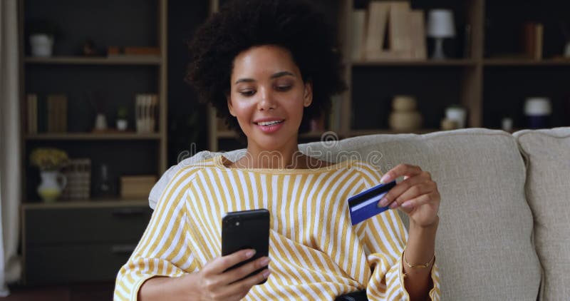 年轻黑人女性信用卡持卡人通过电话在线支付