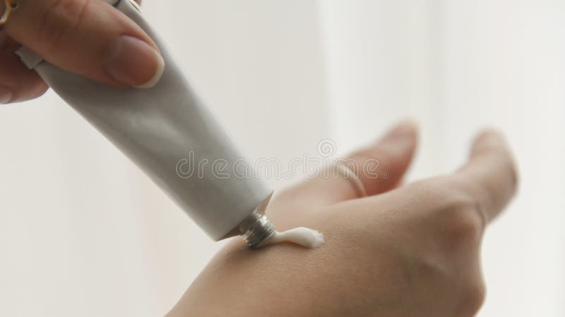 应用皮肤护理的年轻女人白色奶油 免版税库存图片