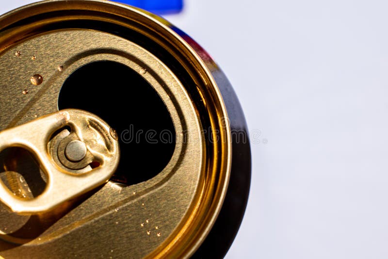 Golden top of opened beer can with liquid drops on white background, canned alcoholic drink, summertime beverage for hot weather. Golden top of opened beer can with liquid drops on white background, canned alcoholic drink, summertime beverage for hot weather