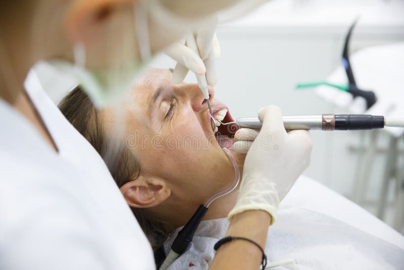 Woman getting her gum pocket depth measured with periodontal probe, held by dental hygienist, examining progression of periodontal disease. Dental hygiene, periodontal disease, prevention concept. Woman getting her gum pocket depth measured with periodontal probe, held by dental hygienist, examining progression of periodontal disease. Dental hygiene, periodontal disease, prevention concept.