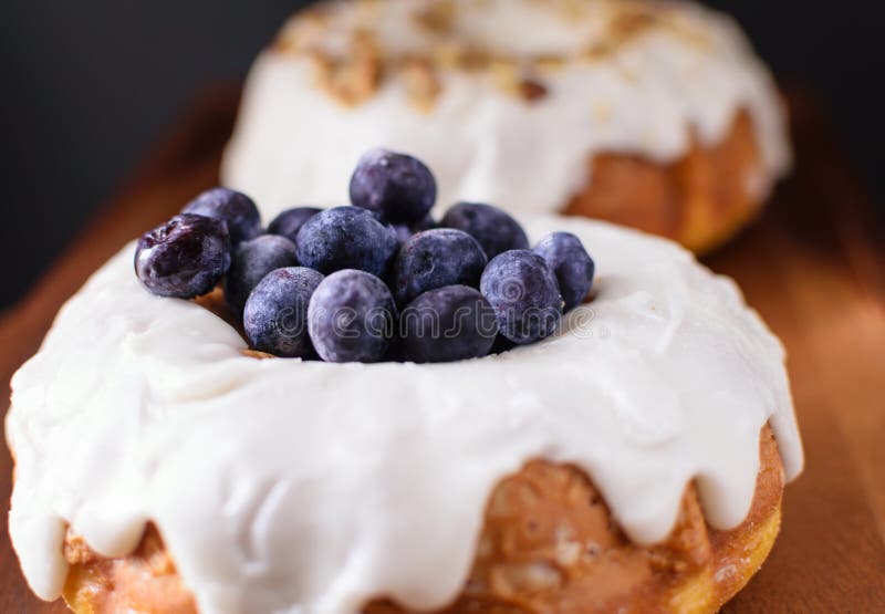 Closeup delicious tempting blueberry and pecan toppings on white vanilla glazing. Closeup delicious tempting blueberry and pecan toppings on white vanilla glazing.