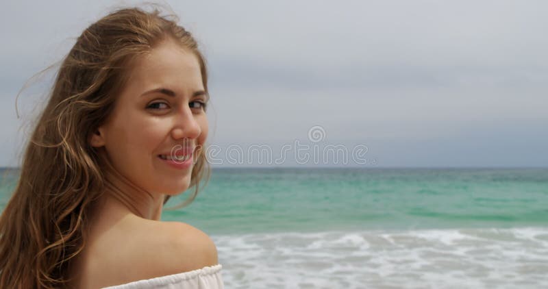 微笑在海滩4k的白种人妇女侧视图