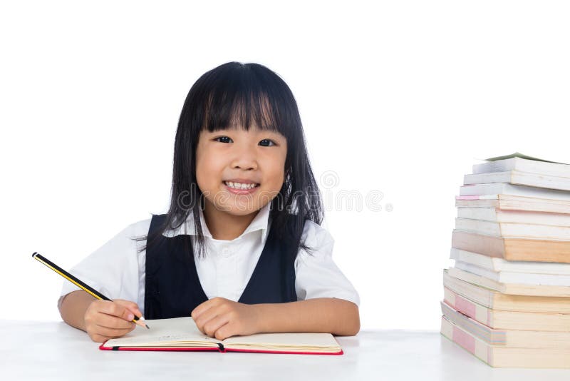 微笑的亚洲中国小女孩佩带的校服studyin 免版税库存照片