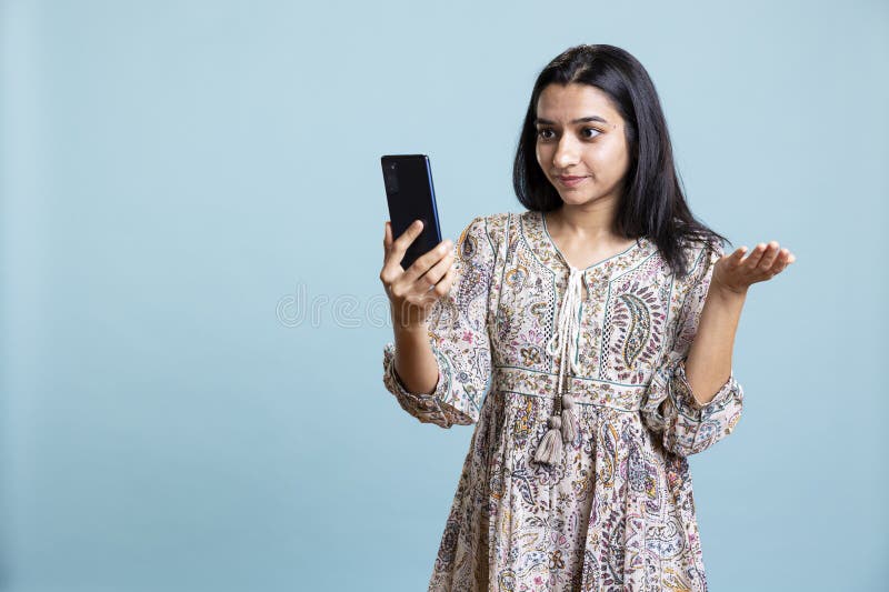 微笑的年轻女子用智能手机与朋友通电话 免版税图库摄影