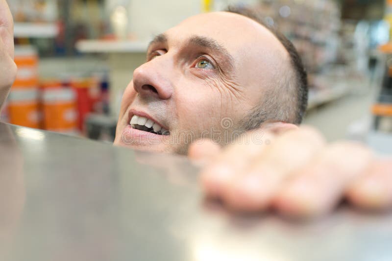 微笑的男人举着架子，抬起头来 免版税库存照片