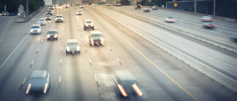 Panorama aerial view rush hour traffic in downtown Houston, Texas, US. Long exposure slow motion many cars commute on interstate highway at late afternoon with light trail, high-occupancy vehicle lane. Panorama aerial view rush hour traffic in downtown Houston, Texas, US. Long exposure slow motion many cars commute on interstate highway at late afternoon with light trail, high-occupancy vehicle lane