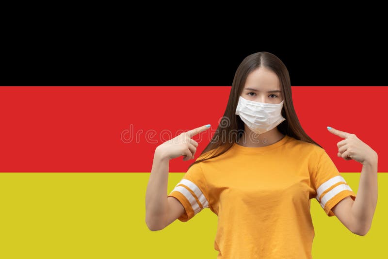 德国冠状病毒的防护 带复制空间的旗帜背景上戴抗菌医用口罩的小女孩 免版税库存照片 德国冠状病毒的防护 带复制空间的旗帜背景上戴抗菌医用口罩的小女孩 免版税库存照片