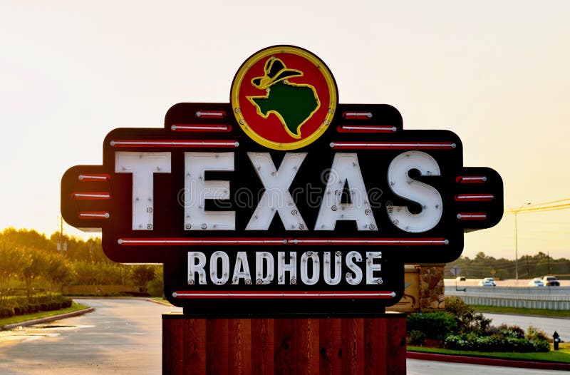 Houston, Texas/USA 09/06/2019: Texas Roadhouse restaurant sign on the side of a freeway in Humble, Texas during an early morning sunrise. Houston, Texas/USA 09/06/2019: Texas Roadhouse restaurant sign on the side of a freeway in Humble, Texas during an early morning sunrise.