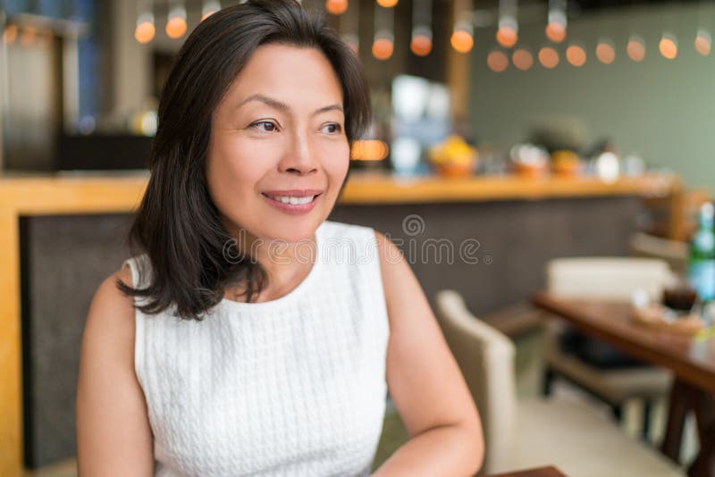 快乐健康的亚洲中年女商人在餐厅里放松 美丽成熟的中国女商人 库存照片 快乐健康的亚洲中年女商人在餐厅里放松 美丽成熟的中国女商人 库存照片