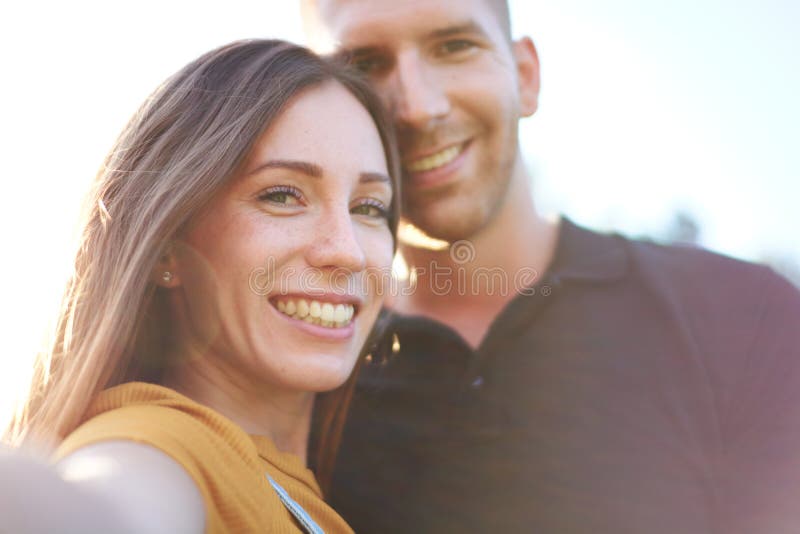 快乐的千禧夫妇在户外自拍 免版税图库摄影