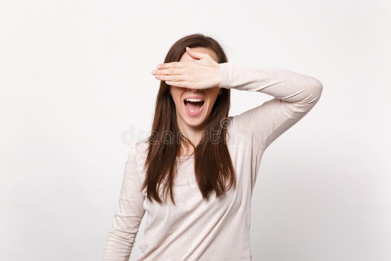 快乐的年轻女人画象盖眼睛的轻的衣裳的用保持嘴开放的手被隔绝在白色墙壁上 库存照片 快乐的年轻女人画象盖眼睛的轻的衣裳的用保持嘴开放的手被隔绝在白色墙壁上 库存照片
