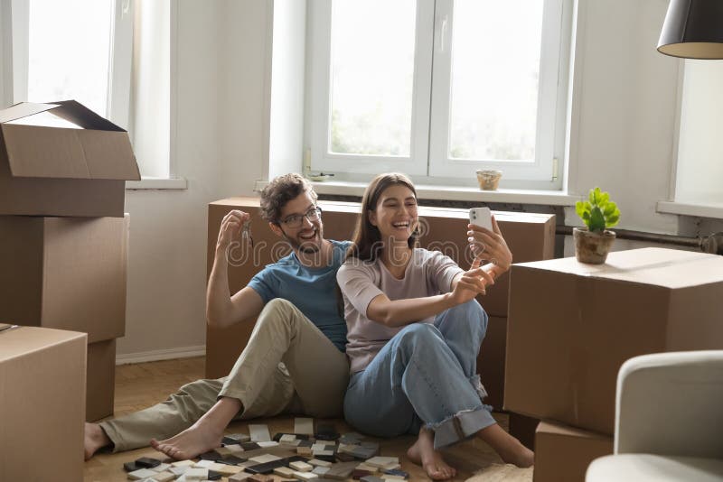 欢喜的年轻夫妇拍摄新公寓钥匙的自拍照 库存图片