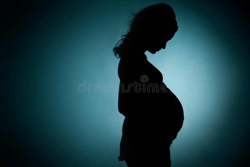 Silhouette of pregnant young lady in studio. green background. Silhouette of pregnant young lady in studio. green background