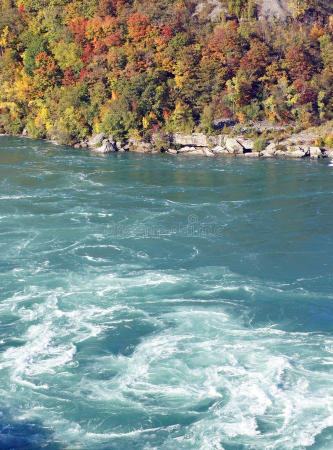 Rapids swirl around the rocky shoreline in the Upper Niagara River, acting as the border between Canada and the United States of America. Rapids swirl around the rocky shoreline in the Upper Niagara River, acting as the border between Canada and the United States of America