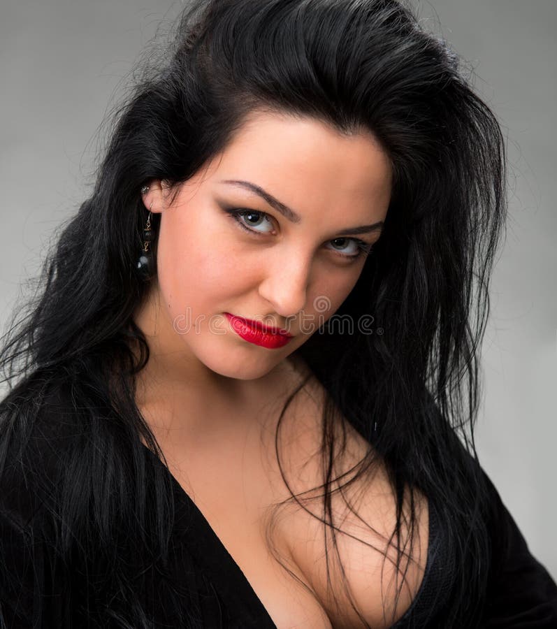 Portrait of woman in black dress on a gray background. Portrait of woman in black dress on a gray background