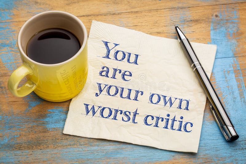 You are your own worst critic - handwriting on a napkin with a cup of espresso coffee. You are your own worst critic - handwriting on a napkin with a cup of espresso coffee