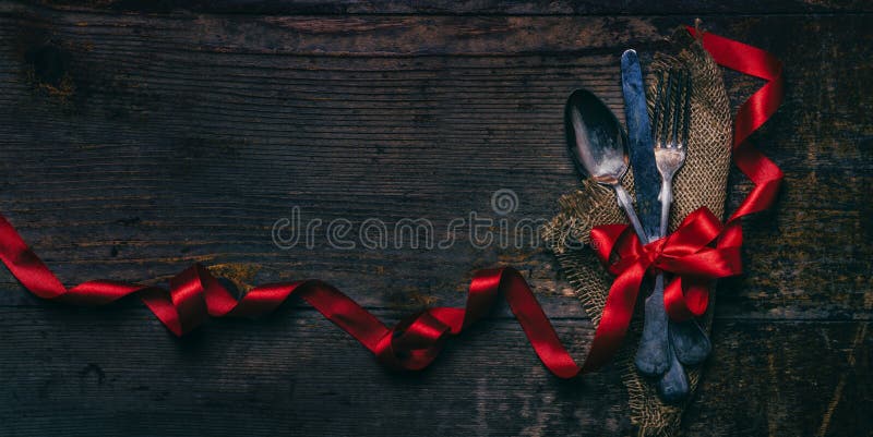 情人节晚餐背景，复古的银器和木桌上的红丝带. 浪漫的豪华餐厅菜单 免版税图库摄影