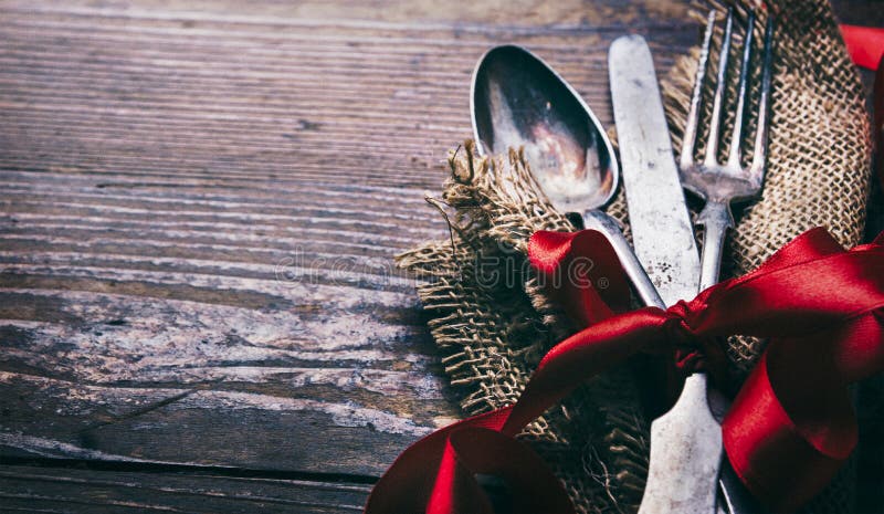 情人节晚餐背景，复古的银器和木桌上的红丝带. 浪漫的豪华餐厅菜单 库存照片