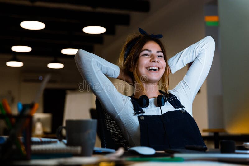 愉快的使用个人计算机计算机工作的年轻女人图表设计师与片剂在晚上在办公室 免版税库存照片 愉快的使用个人计算机计算机工作的年轻女人图表设计师与片剂在晚上在办公室 免版税库存照片