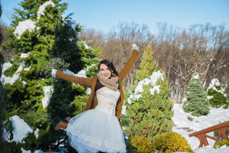 愉快的美丽的新娘在一个多雪的冬日 晴朗的天气 时髦 手工制造婚礼的花束使由杉木树 mitte 免版税图库摄影 愉快的美丽的新娘在一个多雪的冬日 晴朗的天气 时髦 手工制造婚礼的花束使由杉木树 mitte 免版税图库摄影