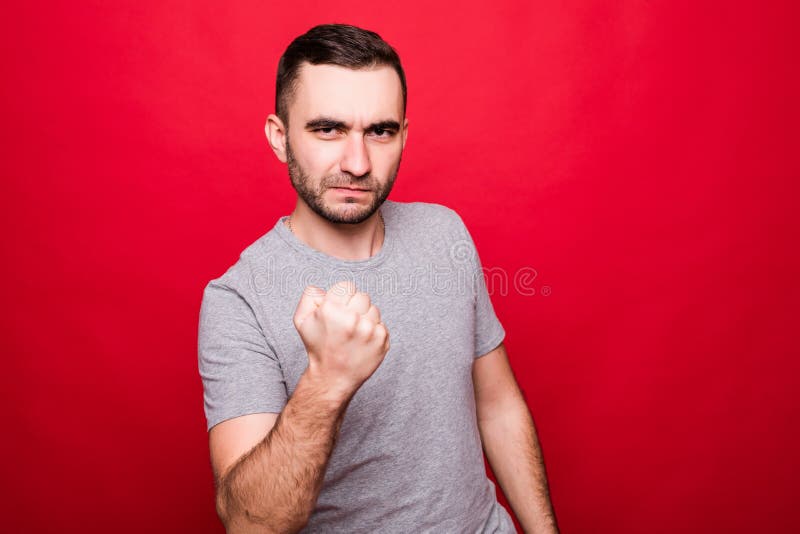 Angry young man show clenched fist threaten or give warning demonstrate threat or menace. Angry young man show clenched fist threaten or give warning demonstrate threat or menace