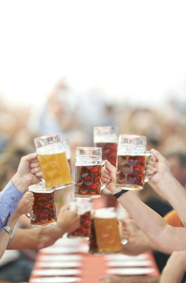 Oktoberfest beer drinkers raise their glasses to toast. Oktoberfest beer drinkers raise their glasses to toast