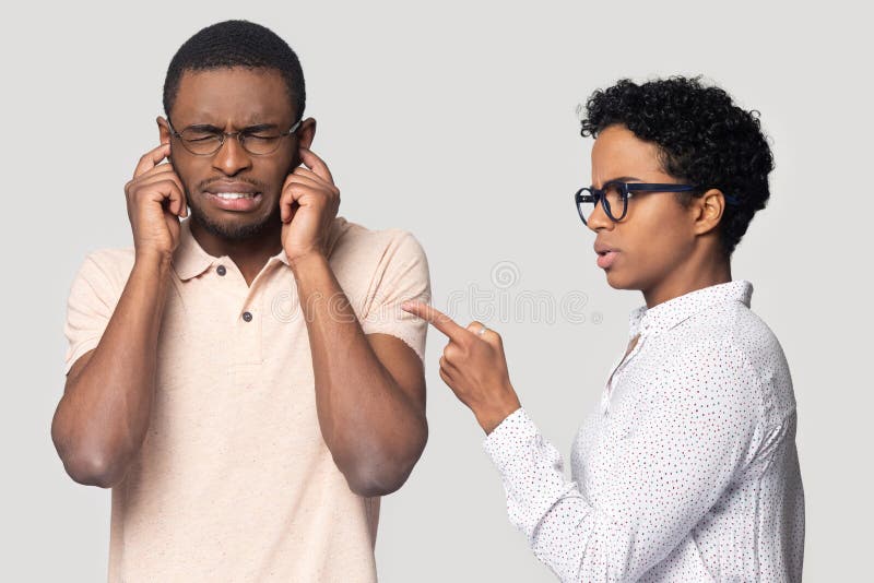 Annoyed african American men in glasses isolated on grey studio background close eyes plug ears avoid angry women lecturing, unhappy black male ignore furious girlfriend talk blaming or scolding. Annoyed african American men in glasses isolated on grey studio background close eyes plug ears avoid angry women lecturing, unhappy black male ignore furious girlfriend talk blaming or scolding