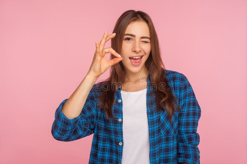 I`m ok! Portrait of cheerful optimistic girl in shirt winking at camera and gesturing okay sign, completely agree with suggestion, confident in success. indoor studio shot isolated on pink background. I`m ok! Portrait of cheerful optimistic girl in shirt winking at camera and gesturing okay sign, completely agree with suggestion, confident in success. indoor studio shot isolated on pink background