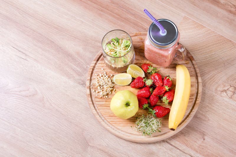 Detox cleanse drink, fruits and berries smoothie ingredients. Natural, organic healthy juice for weight loss diet or fasting day. Mason jar of dietary drink with strawberries, microgreens and banana. Detox cleanse drink, fruits and berries smoothie ingredients. Natural, organic healthy juice for weight loss diet or fasting day. Mason jar of dietary drink with strawberries, microgreens and banana.