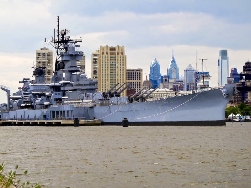 Battleship docked on the Delaware River with Philadelphia skyline in the background. Battleship docked on the Delaware River with Philadelphia skyline in the background.