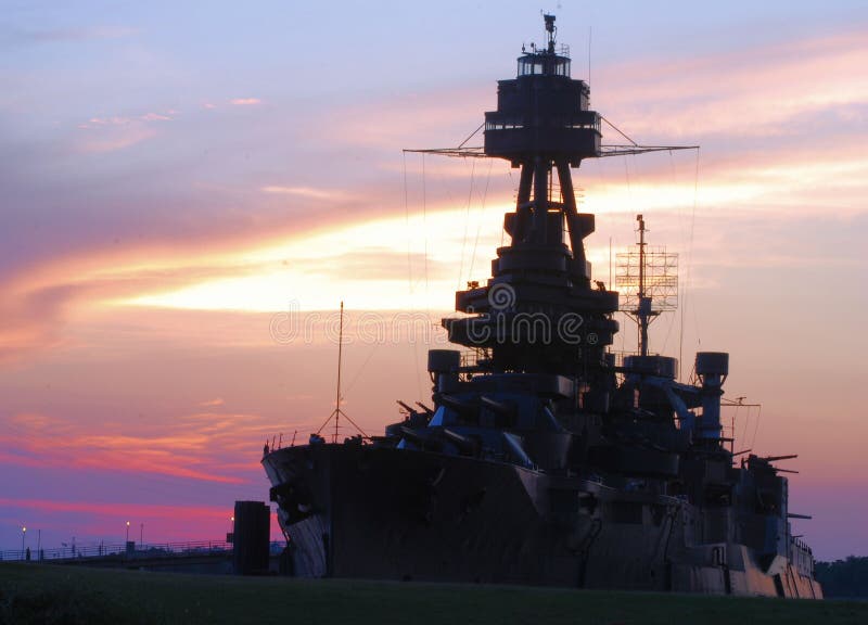 The historic monument USS Texas Battleship against a sunset sky. The historic monument USS Texas Battleship against a sunset sky.