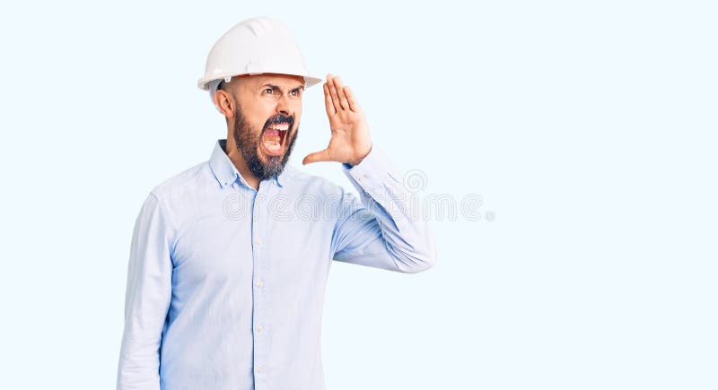 戴着建筑师硬帽的年轻帅哥大声喊叫，用手站在嘴边 库存图片