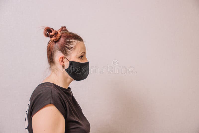 戴防护面具的女孩，灯光背景上的有趣发型 库存照片
