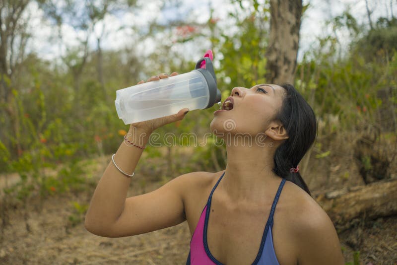 户外年轻有吸引力的疲乏和渴亚裔妇女饮用水生活方式画象在坚硬连续锻炼冷却以后的 免版税图库摄影 户外年轻有吸引力的疲乏和渴亚裔妇女饮用水生活方式画象在坚硬连续锻炼冷却以后的 免版税图库摄影