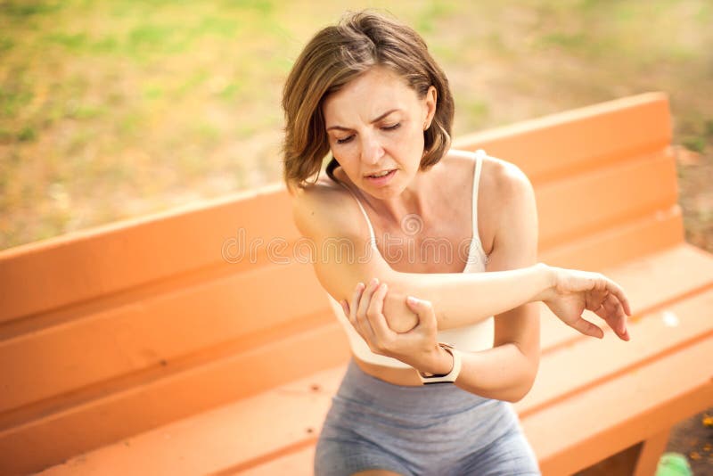 户外肘痛运动妇女. 医疗理念 库存照片
