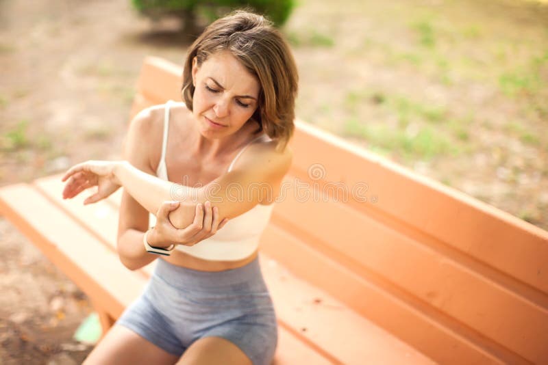 户外肘痛运动妇女. 医疗理念 免版税库存照片