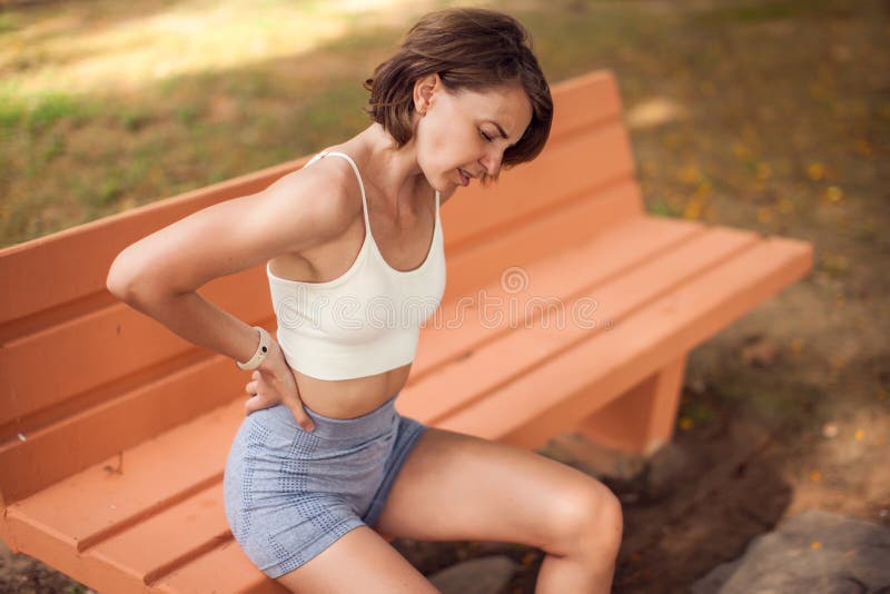 户外背痛的女人. 健康保健与医学概念 库存图片