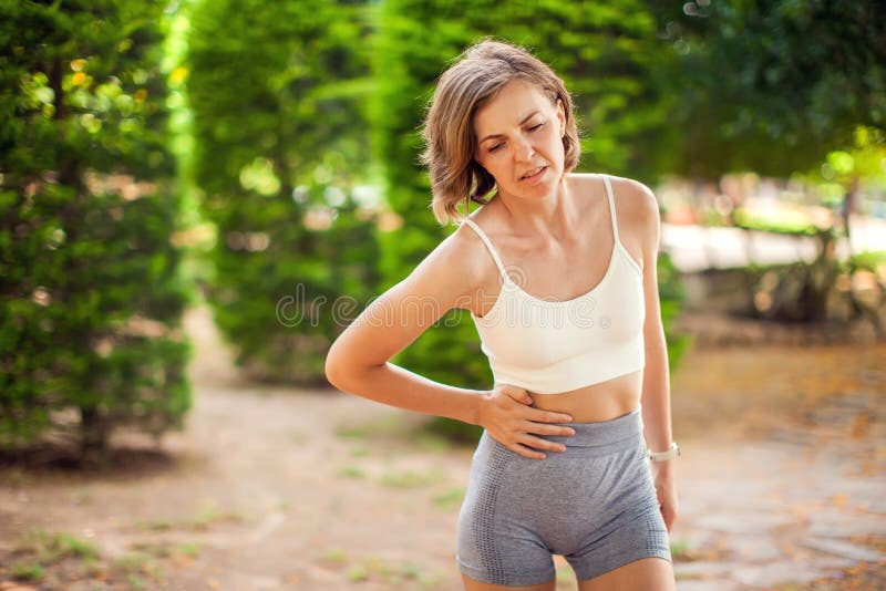 户外腹痛运动妇女. 健康保健与医学概念 图库摄影