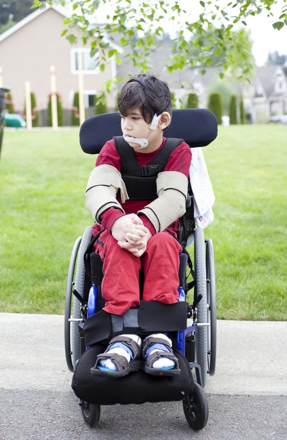 户外轮椅的残疾小男孩 免版税库存照片