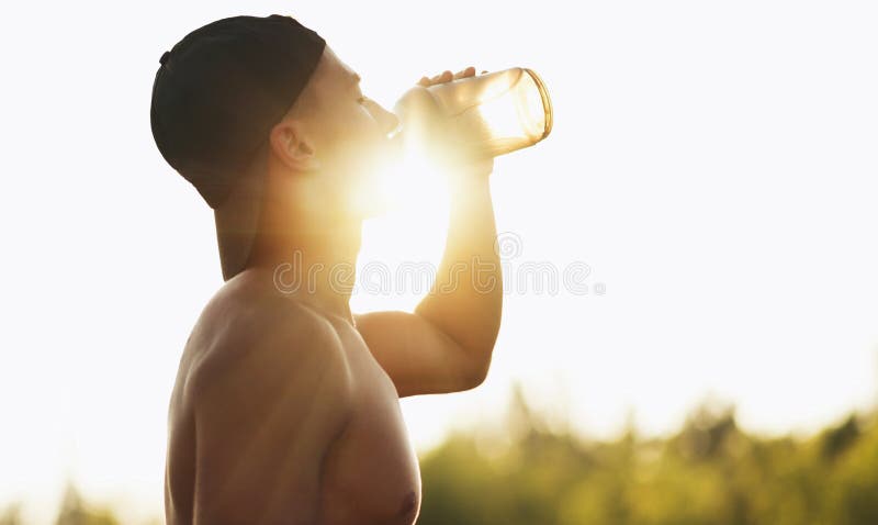 Portait of fitness male drinking water out of plastic bottle after workout outdoor on sunlight. Sportsman hydrating during outside training on sports ground. Tired fitness man taking a break. Portait of fitness male drinking water out of plastic bottle after workout outdoor on sunlight. Sportsman hydrating during outside training on sports ground. Tired fitness man taking a break