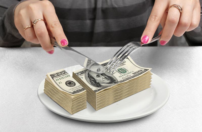 Hands cut money on plate, reduce funds concept. Hands cut money on plate, reduce funds concept