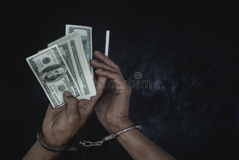 Hand young man in handcuffed hold money, Police arrest drug trafficker with handcuffs. Law and police concept. Hand young man in handcuffed hold money, Police arrest drug trafficker with handcuffs. Law and police concept.