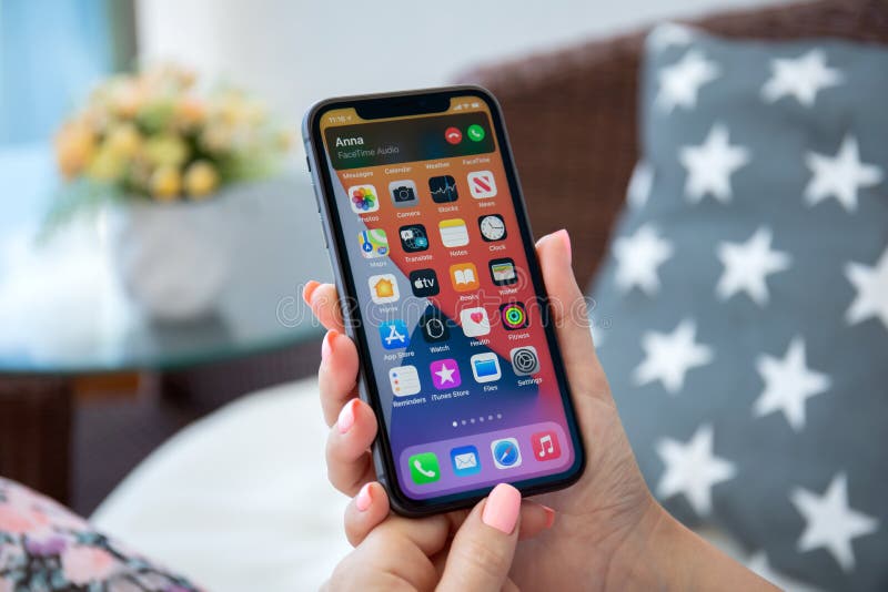 Alanya, Turkey - August 9, 2020: Woman hand holding iPhone 11 IOS 14 with phone call widget on the home screen. iPhone 11 was created and developed by the Apple inc. Alanya, Turkey - August 9, 2020: Woman hand holding iPhone 11 IOS 14 with phone call widget on the home screen. iPhone 11 was created and developed by the Apple inc