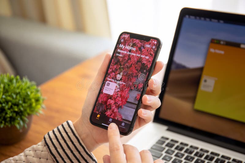 Anapa, Russia - September 26, 2018: Woman hand holding iPhone X with app Home in the screen. iPhone 10 was created and developed by the Apple inc. Anapa, Russia - September 26, 2018: Woman hand holding iPhone X with app Home in the screen. iPhone 10 was created and developed by the Apple inc